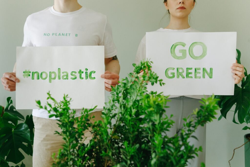 Two people holding eco-friendly signs promoting sustainability and going green.